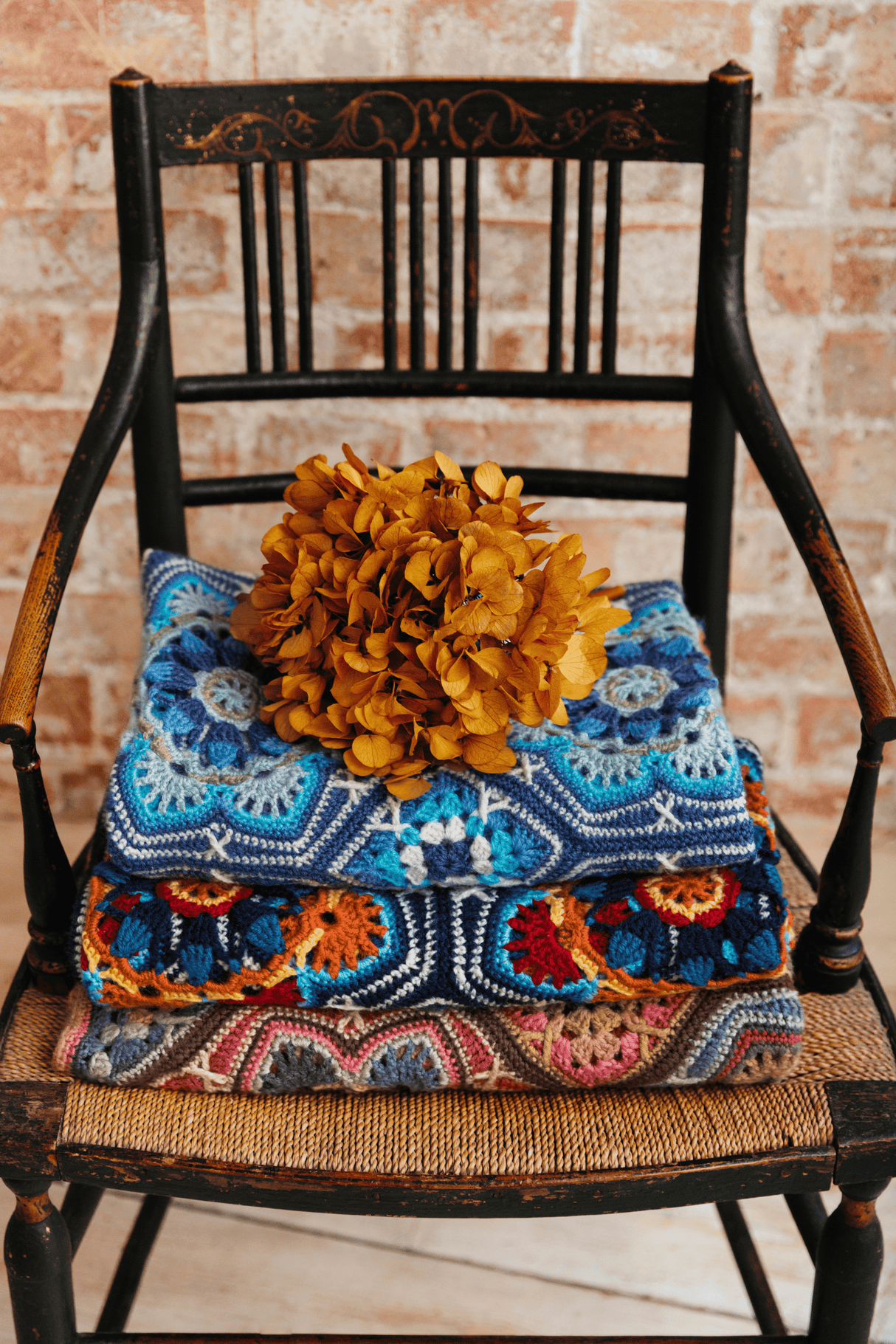 Janie Crow's Persian Tiles Trow Crochet Afghan in Sandlewood Dark Blue and Light Blue on rocking chair